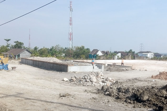 SIBUK: Para pekerja terlihat membangun bangunan berbentuk persegi panjang di bagian depan kawasan yang bakal dijadikan Taman Budaya Cepu kemarin.