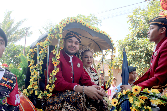 SAKRAL: Istri dari Habib Luthfi bin Yahya, Umi Syarifah Salma (kiri) menunggang kereta mengiringi kirab Merah Putih.