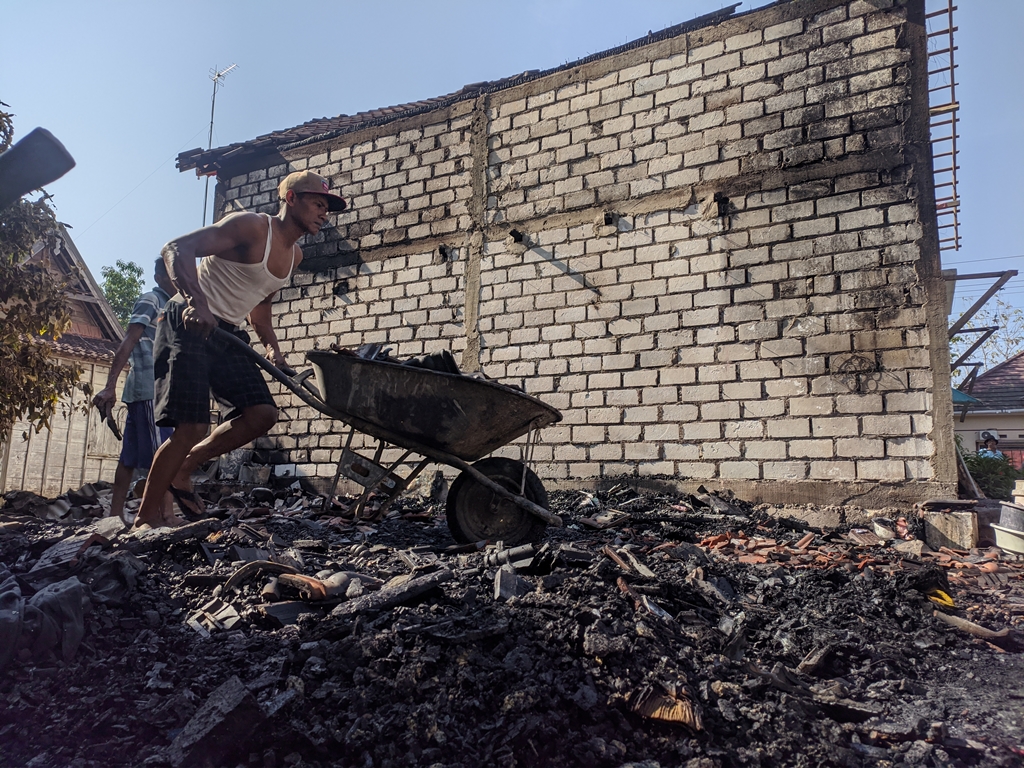BERSIHKAN: Warga bahu membahu membersihkan puing-puing sisa kebakaran rumah milik Mbah Lasmi, Puji Lestari dan Eko Prasetio pada Jumat (15/9).