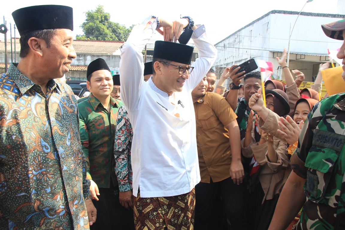 SAPA MASYARAKAT: Menteri Sandiaga Salahudin Uno membuat lambang love atau cinta kepada para siswi saat kunjungan Islam Nusantara di kompek Masjid Jami