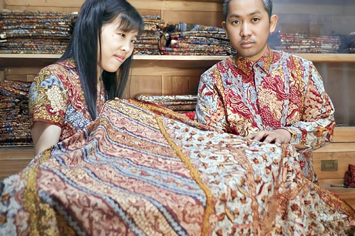 MENDUNIA: Henry Setiawan dan Renny memperlihatkan batik tulis Lasem karya Maranatha Ongs.