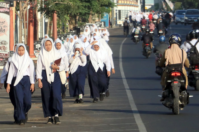 KEARIFAN LOKAL: Para pelajar pergi ke sekolah di Jalan Sunan Kudus kemarin pagi.