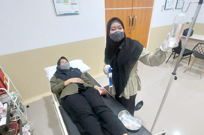 DIRAWAT: Tenaga medis merawat salah satu pasien di salah satu kliniki di Pati belum lama ini.