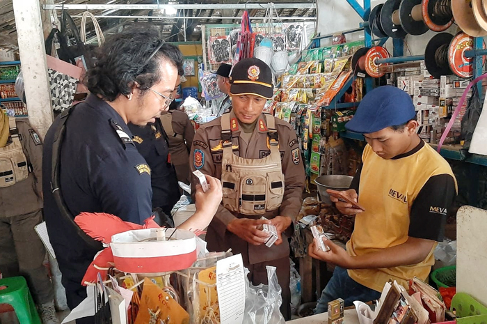 OPERASI: Petugas gabungan melaksanakan razia rokok ilegal disejumlah warung, Rabu (27/9).