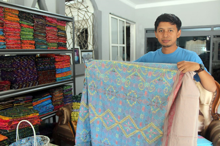 BERTAHAN: Aris Subagio, salah satu pengusaha tenun Troso menunjukkan salah satu produknya.
