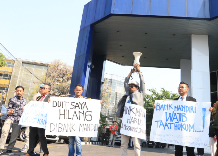 MINTA UANGNYA KEMBALI: Aksi nasabah Bank Mandiri Kudus menyuarakan hatinya untuk menarik perhatian masyarakat yang melintas.