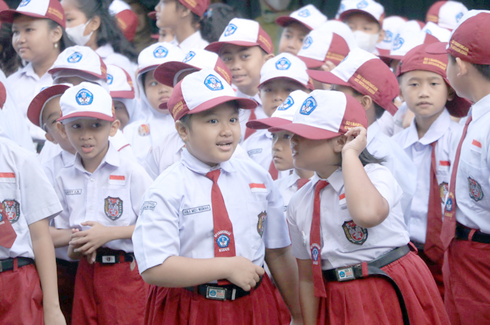 RIANG GEMBIRA: Siswa SD berseragam dan memakai topi berbaris rapi dan tertib saat mengikuti upacara di sekolah baru-baru ini.