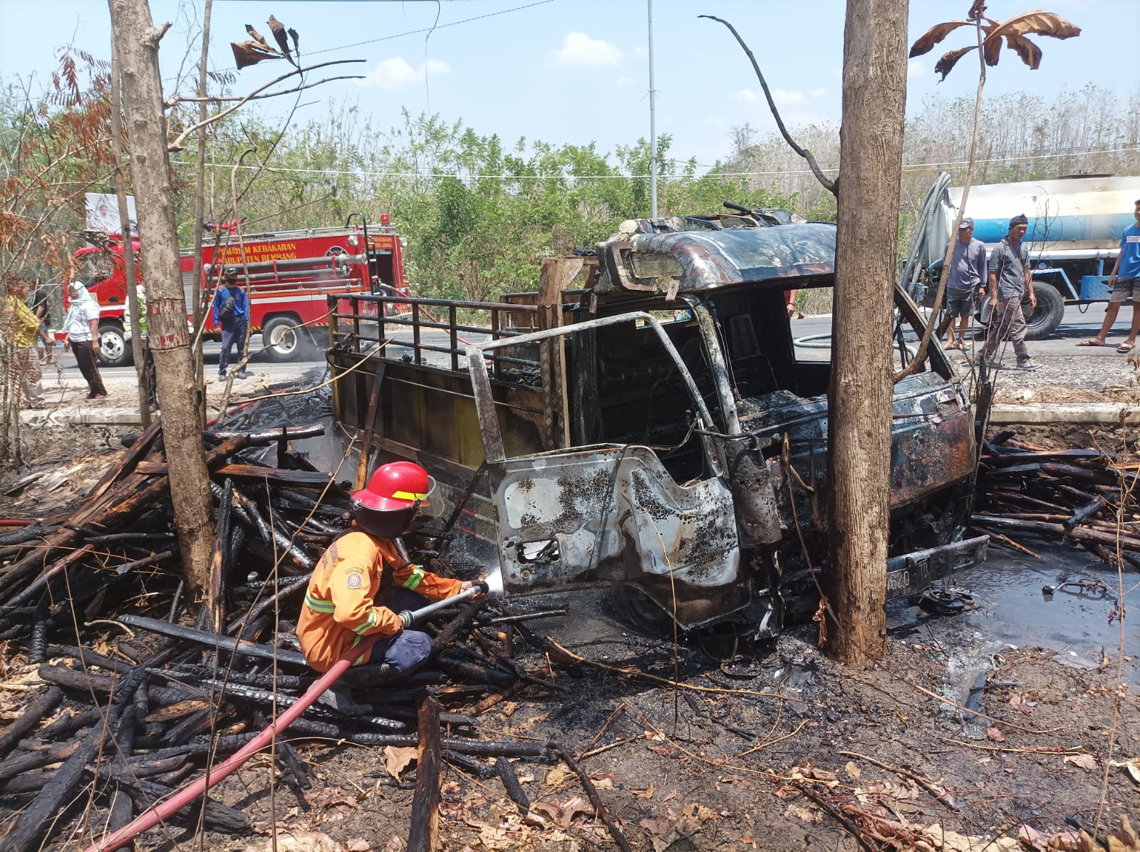 LUDES: Petugas pemadam kebakaran mencoba memadamkan api pada body truk di Jalan Raya Blora-Rembang pada Jumat (6/10).
