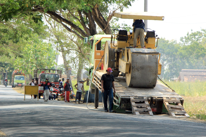 DIPERBAIKI: Slender diturunkan untuk perbaiki jalan barat gapura desa Ketangi, Pamotan, Senin (16/10).