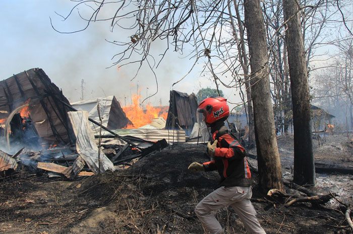DIPADAMKAN: Petugas Damkar Rembang mencoba padamkan gudang kayu jati di Kedungsikul, Sumberjo, Rembang, Minggu (22/10).