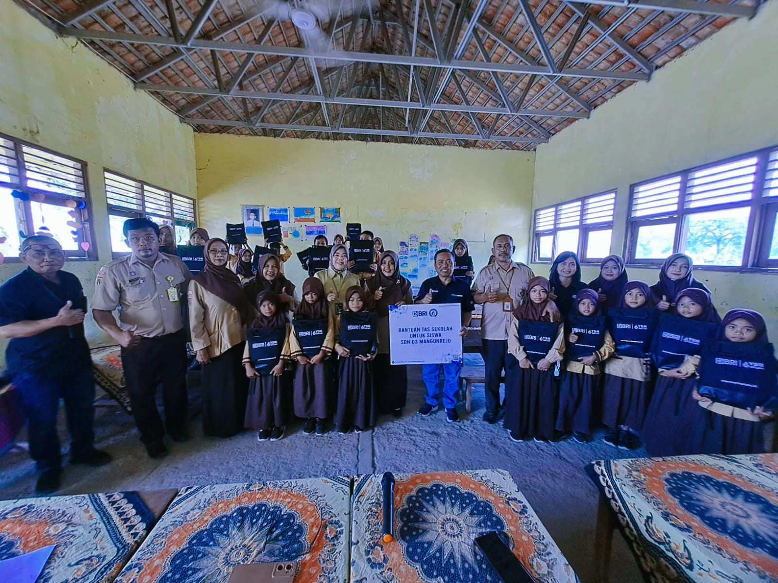 SERAHKAN BANTUAN: Pemimpin Cabang BRI Purwodadi Stefanus Juarto menyerahkan bantuan tas kepada siswa SD N 3 Mangunrejo, Kecamatan Pulokulon, pada Jumat (27/10).