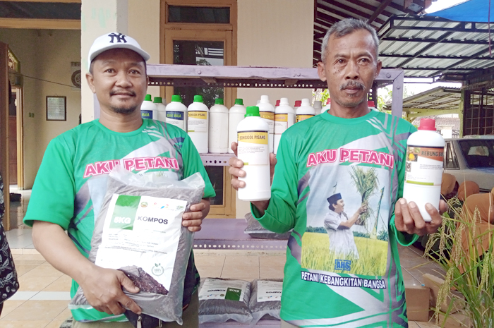 UNJUK GIGI: Supardi (kanan) saat menunjukkan pestisida dan pupuk organik buatannya.