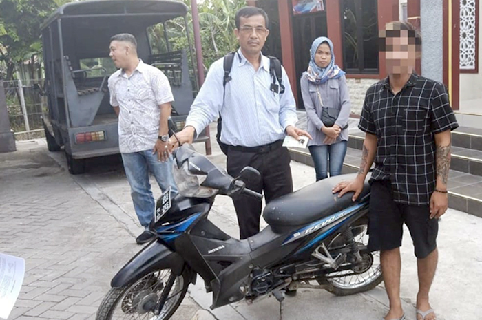 GADAIKAN MOTOR: Tersangka GK bersama dengan barang bukti sepeda motor yang diamankan di Mapolsek Godong, Selasa (7/11).