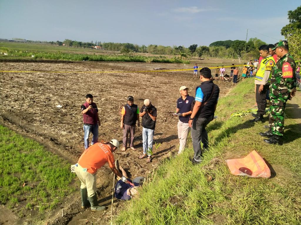 IDENTIFIKASI: Anggota Inafis Polres Grobogan melakukan pemeriksaan kepada korban kesetrum di area persawahan Desa Tanggungharjo, Kecamatan Grobogan.