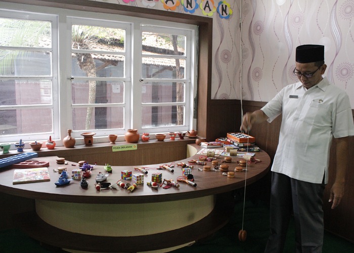 Kepala SMP Muhammadiyah 1 Kudus Ali Zamroni mencoba permainan yoyo di pojok dolanan tradisional perpustakaan milik SMP Muhammadiyah 1 Kudus