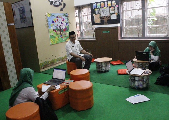 Guru saat berada di ruang diskusi perpustakaan SMP Muhammadiyah 1 Kudus dengan kursi dan meja yang terbuat dari bistik