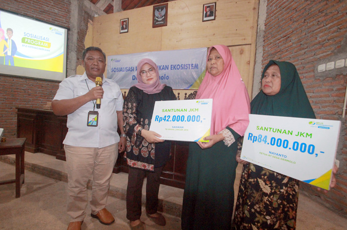 PEDULI: Kepala Kantor Cabang Pratama BPJamsostek Kabupaten Jepara Mulyadi bersama Petinggi Dermolo Riyati menyerahkan klaim JKM kepada ahli waris peserta asal Dermolo, Kembang.