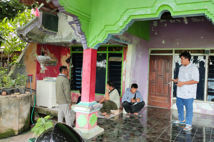 TAK ADA PENGHUNI: Sejumlah warga menggereduk rumah pelaku penipuan agen penyaluran TKI di Desa Kalirejo, Undaan, Kudus, Kamis (23/11).
