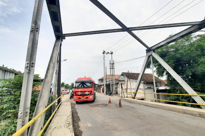 PEDULI: Warga sekitar lokasi saat memotong besi lantai jembatan Getasrejo Kecamatan Grobogan yang membahayakan pengendara.