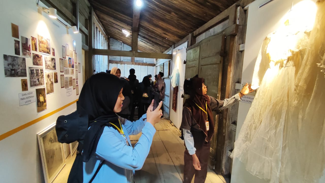 BERSEJARAH: Pengunjung Museum Nyah Lasem sedang mengabadikan koleksi gaun pengantin tahun 1930-an beberapa waktu lalu.