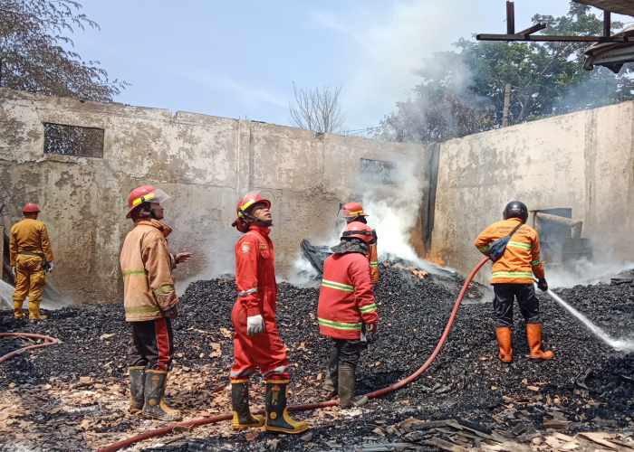 PENDINGINAN: Tim Damkar Rembang menyemprotkan air ke titik api saat terjadi kebakaran&nbsp;di gudang kayu&nbsp;KM Putra milik mantan Bupati Rembang Moch Salim, Minggu (24/12) pagi.