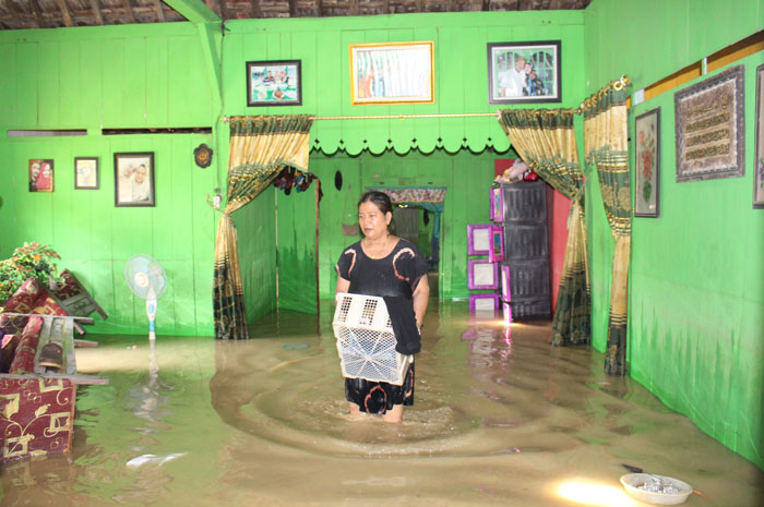 TERABAS BANJIR: Warga Dusun Ngetuk, Desa Ngambakrejo, Kecamatan Tanggungharjo, sedang menyelamatkan baju yang terendam banjir, kemarin.