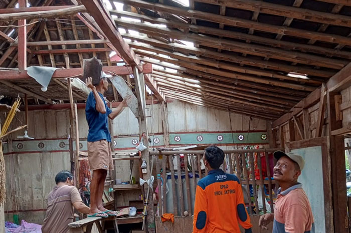 BETULKAN GENTENG: Anggota BPBD Grobogan membantu membetulkan genteng rusak milik warga Desa Sedadi, Kecamatan Penawangan.