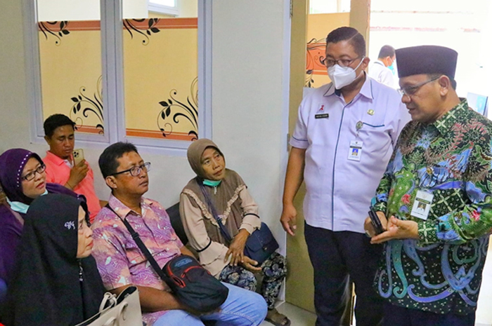 KUNJUNGAN: Penjabat (Pj.) Bupati M Hasan Chabibie berbincang-bincang dengan seorang pasien di ruang tunggu RSUD dr. Loekmono Hadi Kudus kemarin.