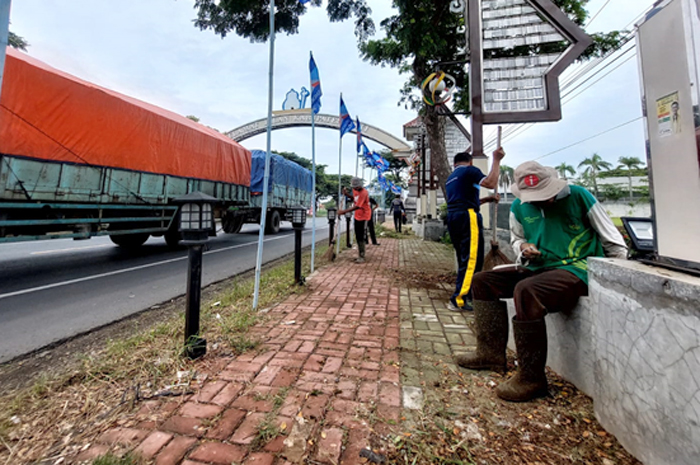 BERSIHKAN RUMPUT: Petugas membersihkan rumput di taman di perbatasan Pati - Kudus pagi kemarin.