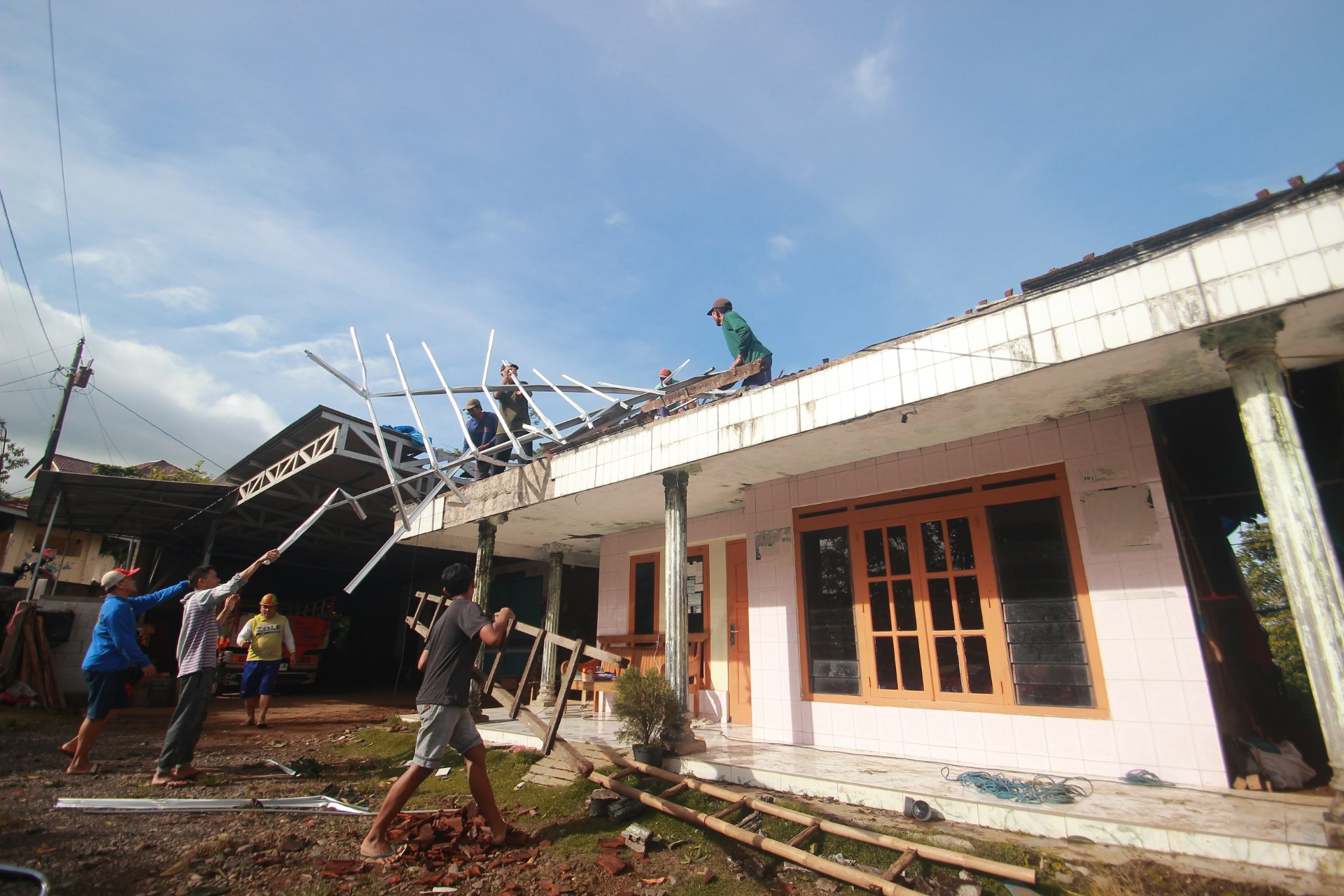 PORAK PORANDA: Warga Desa Kunir bergotong royong membersihkan puing-puing bangunan yang rusak diterpa angin putting beliung.