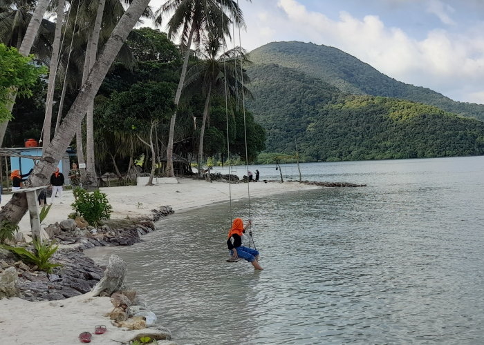 WISATA: Seorang pengunjung bermain di Pulau Bobby Karimunjawa.