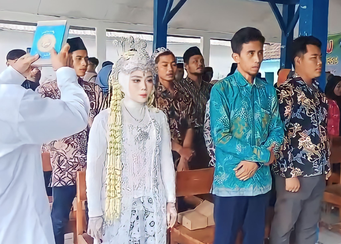 TAMPIL BEDA: Salah satu anggota KPPS di Desa Gunungmulyo, Kecamatan Sarang mengenakan pakaian pengantin saat pelantikanpada Kamis (25/1).