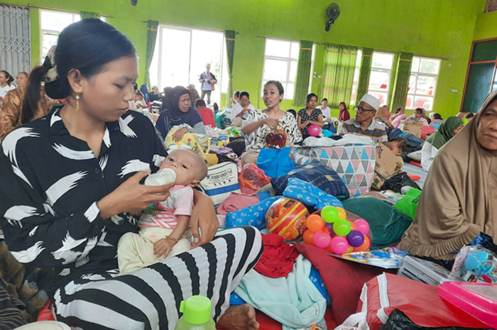 BUTUH SUSU: Siti Solihah, salah satu pengungsi menggendong anaknya yang masih berusia tiga bulan di posko pengungsian Balai Desa Jati Wetan, Kecamatan Jati, Kudus, kemarin.