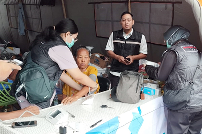 SIAGA KESEHATAN: Petugas kesehatan dari RSUD dr Loekmono Hadi Kudus menangani pasien pengungsi di posko Terminal Induk Kudus.