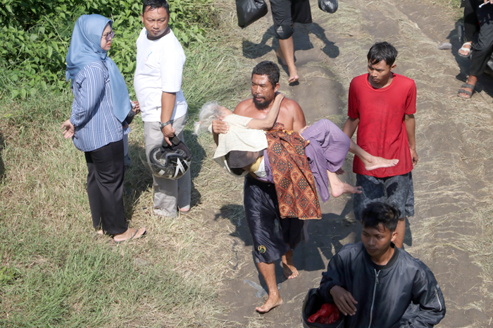 BOPONG NENEK RENTA: Seorang nenek renta korban banjir warga Desa/Kecamatan Karanganyar, Demak, dibopong keluarganya untuk mendapatkan petolongan madis.