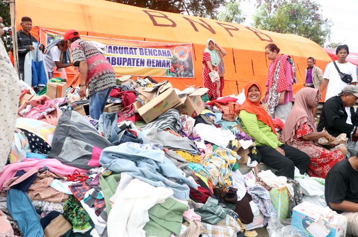 SEADANYA: Sejumlah pengungsi sibuk memilih baju dari bantuan masyarakat di Jembatan Tanggulangin, Kudus, kemarin. untuk gonta ganti karena rumahnya masih terendam banjir.