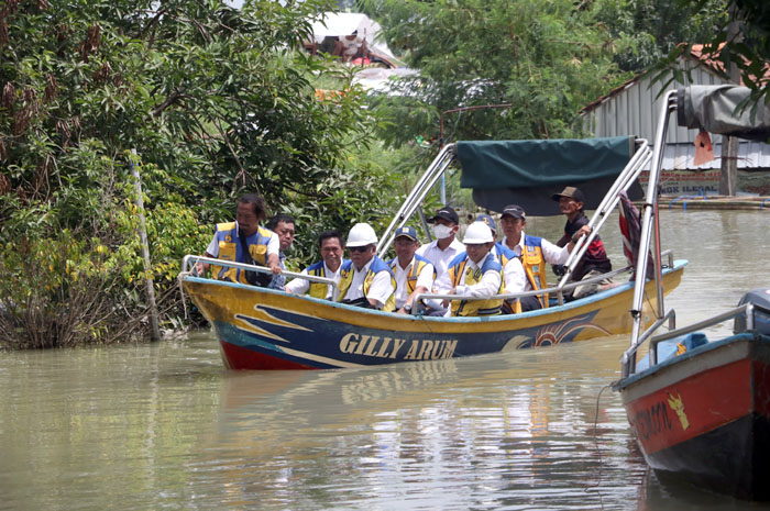 LEWATI BANJIR: Menteri PUPR Basuki Hadimuljono bersama rombongan meninjau tanggul Sungai Wulan yang jebol kemarin. &nbsp;