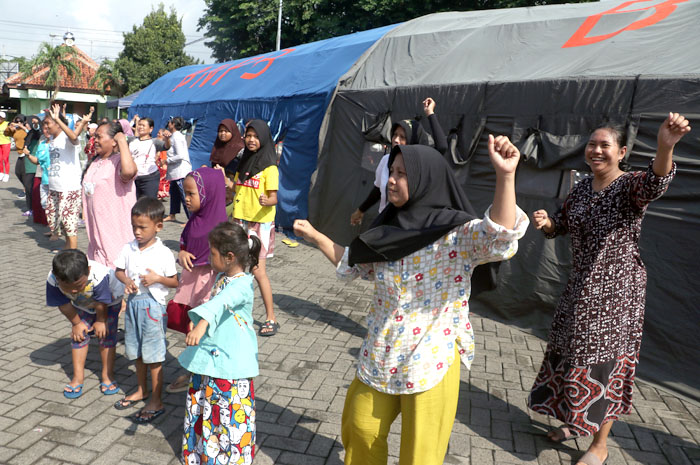 TETAP SENYUM: Untuk menjaga kebugaran para pengungsi senam kebugaran di depan tenda Terminal Induk Jati Kudus.