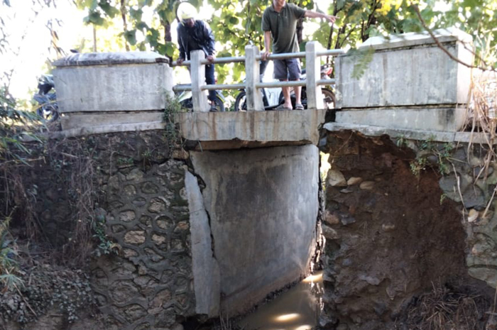 BERBAHAYA: Jembatan penghubung Desa Glapan-Desa Penadaran, Kecamatan Gubug, longsor sedalam tiga meter akibat erosi banjir.