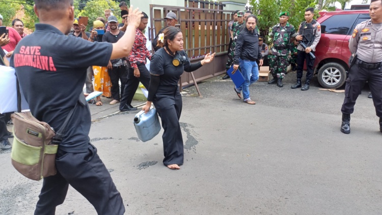 TEATRIKAL: Linda Natalia, aktivis lingkungan sekaligus seniman menuangkan cairan limbah tambak dari Karimunjawa di halaman Pengadilan Negeri Jepara Selasa, (20/2).