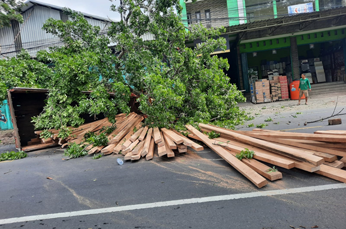 NGGULING: Truk muatan kayu ambyar di Jalan Pantura Kudus-Pati kemarin pagi.