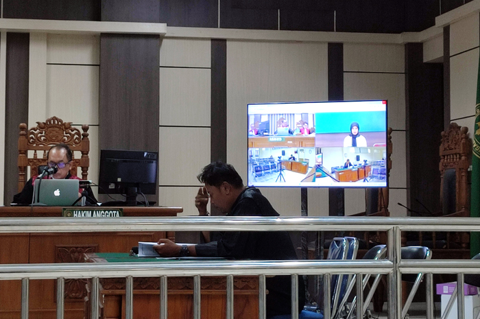 DISIDANG: Terdakwa korupsi dana pengentasan kemiskinan PNPM-MP mengikuti persidangan secara online Rabu (28/2).&nbsp;