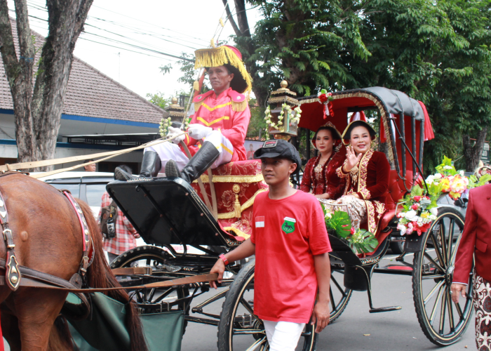 NAIK KERETA KENCANA: Bupati Grobogan Sri Sumarni menyapa warga yang menyalami dari tepi jalan saat prosesi Kirab Boyong Grobog pada Minggu (3/3).
