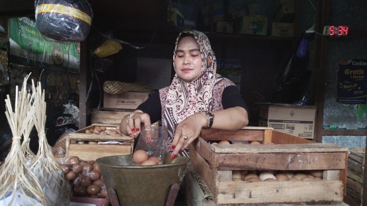 TELUR MAHAL: Pedagang Pasar Bitingan tampak menimbang telur, Senin (4/3).