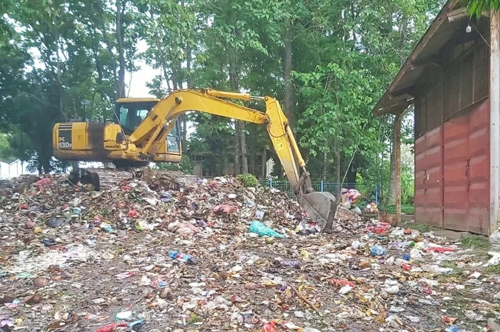 KERUK: Alat berat dikerahkan untuk membersihkan sampah yang meluber di area gerbang TPA Landoh, belum lama ini.