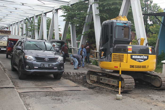 LEWAT: Mobil berwarna hitam saat melintasi jembatan Babalan.
