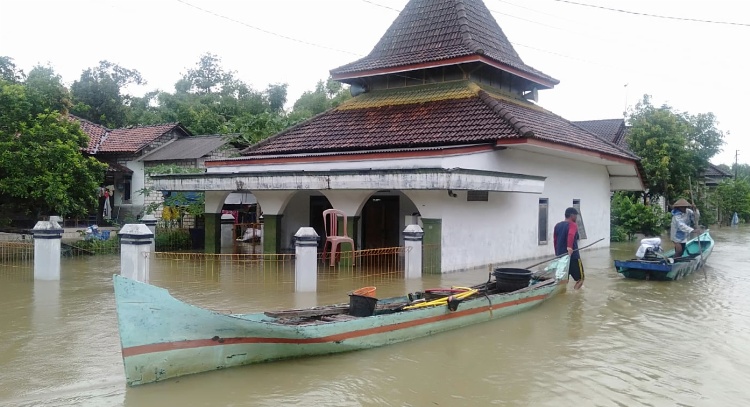 Warga Desa Mintobasuki mengandalkan perahu untuk beraktivitas selama banjir merendam desanya.