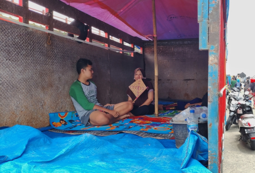 MENGUNGSI: Sejumlah warga memilih mengungsi di bak truk daripada di tempat pengungsian.