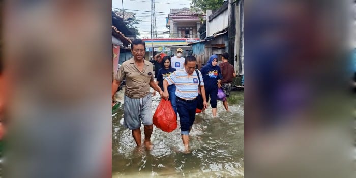 TERJANG BANJIR: Pemimpin Cabang BRI Purwodadi Stefanus Juarto (kanan) menerjang banjir dengan membawa nasi bungkus untuk korban banjir di Purwodadi.