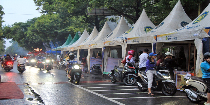MERIAH: Pengendara sepeda motor melintas di depan stand Kampung Ramadan yang akan dikolaborasikan pencegahan inflasi.